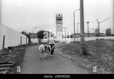 GDR, Berlin, 07. 06. 1990, mur de la Bernauer Strasse (Nordbahnhof), femme avec chien, tour de guet, C Rolf Zoellner Banque D'Images