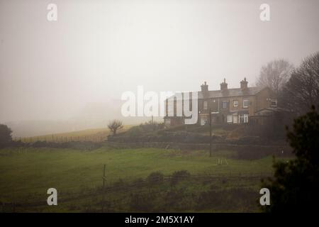 West Yorkshire, Royaume-Uni. 30th décembre 2022. Le UK Weather Mist dévie autour des chalets et des maisons de la vallée de Shibden près de Halifax, dans le West Yorkshire. La vallée de Shibden a été rendue célèbre comme l'endroit pour le tournage du drame de la BBC, Jack Gentleman. Crédit : Windmill Images/Alamy Live News Banque D'Images