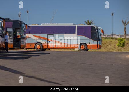 Bus ou autobus garés sur un parking en face d'un immeuble résidentiel à Oran, en Algérie. Grand parking avec autocars à Oran. Banque D'Images