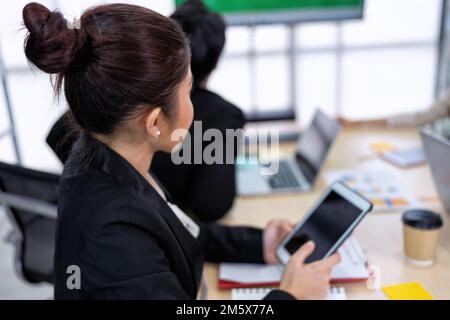 Jeune femme d'affaires travaillant dans le bureau utiliser la tablette de vérification des graphiques financiers et des informations de graphiques Banque D'Images