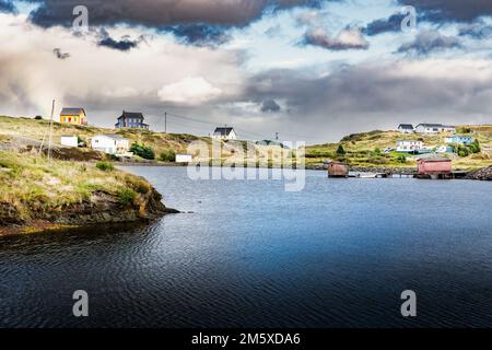 Petites maisons de plage rustiques colorées et chalet vivant sur des promontoires rocheux avec une maison de bateau sous un ciel spectaculaire près de Port Rexton Terre-Neuve Canada. Banque D'Images