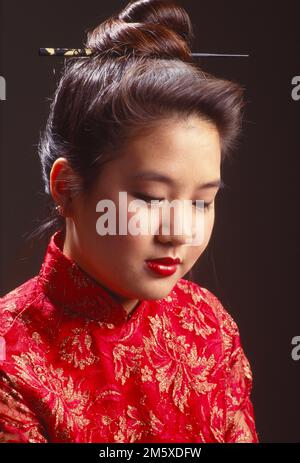 Jeune femme asiatique vêtue d'un kimono à l'aspect pensif qui se glissera vers le bas Banque D'Images