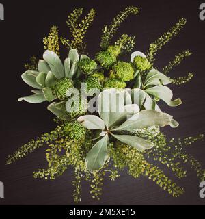 arrangement de fleurs dans un vase en verre, un bouquet de fleurs mélangées de chrysanthèmes verts dans le salon sur une table noire Banque D'Images
