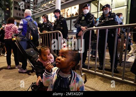 Hong Kong, Hong Kong, Chine. 31st décembre 2022. Deux enfants réagissent devant les policiers de Hong Kong alors que les gens prennent part aux célébrations du nouvel an, après que le gouvernement ait annoncé l'assouplissement des mesures anti Covid. (Credit image: © Daniel CEng Shou-Yi/ZUMA Press Wire) Credit: ZUMA Press, Inc./Alamy Live News Banque D'Images