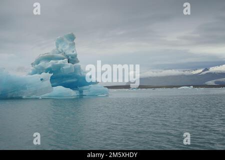 Grand iceberg bleu flottant à la surface du lac glacier de Jokulsarlon, Islande Banque D'Images