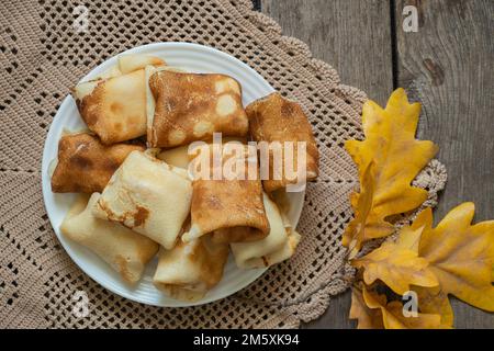 des crêpes enveloppées sur une assiette pour le petit déjeuner sont sur la table dans la cuisine, des crêpes pour le petit déjeuner Banque D'Images