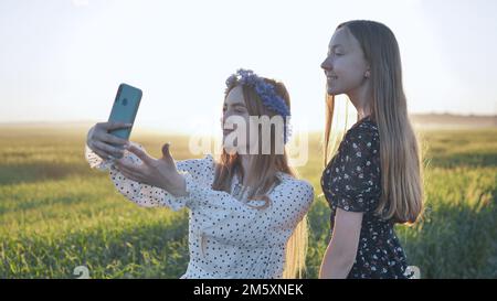 Deux filles ukrainiennes posant pour des selfies dans un champ. Banque D'Images