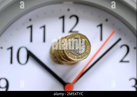 PILE D'UNE LIVRE DE PIÈCES SUR LA FACE DE L'HORLOGE RE COÛT DE LA VIE CRISE PENSIONS INFLATION DES REVENUS BUDGETS DES MÉNAGES ETC ROYAUME-UNI Banque D'Images