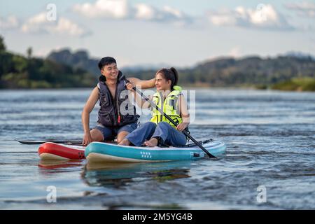 Pendant les vacances d'été amour couple de détente voile sup surf sur la rivière sur belle nature calme rivière Banque D'Images