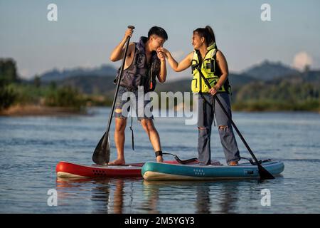 Amour couple voile sup surf surf sur la rivière et proposé de se marier à la fille ami le jour de la Saint-Valentin Banque D'Images