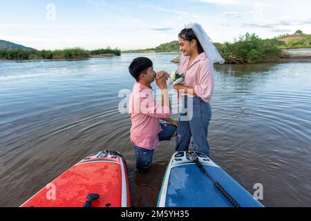 Amour couple voile sup surf surf sur la rivière et proposé de se marier à la fille ami le jour de la Saint-Valentin Banque D'Images