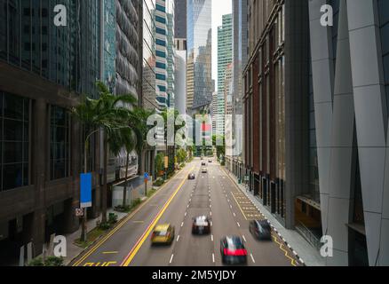 Rue et voiture sur la circulation se déplaçant dans le quartier financier d'affaires du centre-ville avec gratte-ciel bâtiment le matin à Singapour. Banque D'Images