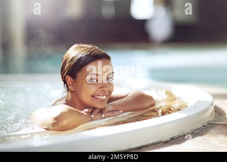 Réservez une journée au spa. L'eau que vous attendez. une jeune femme attrayante se relaxant dans un jacuzzi intérieur dans un spa de beauté. Banque D'Images