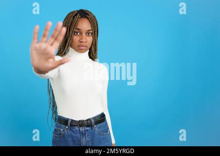 Une femme africaine qui fait des gestes s'arrête avec la paume de la main Banque D'Images