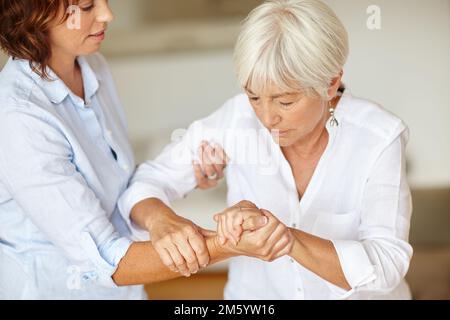 Offrir à sa mère une main d'aide. une femme qui aide sa mère âgée. Banque D'Images