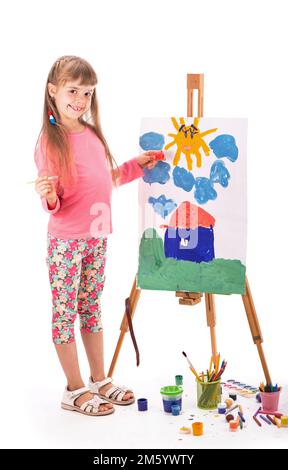 L'enfant dessine une maison. Peinture pour enfants. Petite fille tire le soleil. L'élève fait ses devoirs à l'art. Arts et artisanat pour les enfants. Peinture Banque D'Images