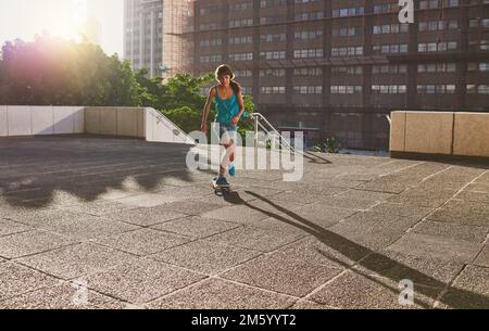 Je skate ce qui est votre super puissance. une jeune femme patinant dans la ville. Banque D'Images