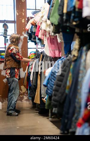 Un membre du personnel organise la vente de vêtements à la boutique de charité TRAID, Dalston, est de Londres. TRAID, une association caritative qui s'efforce d'empêcher la mise au rebut des vêtements, a détourné 3 222 tonnes de vêtements de la décharge et de l'incinération en 2022, réduisant les émissions de CO2 de 30 609 tonnes et réutilisant plus de 11,2 millions de vêtements. Date de la photo: Vendredi 25 novembre 2022. Banque D'Images