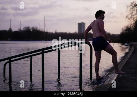 Un homme prend une baignade tôt le matin le jour de l'an au Serpentine à Londres. Date de la photo: Dimanche 1 janvier 2023. Banque D'Images