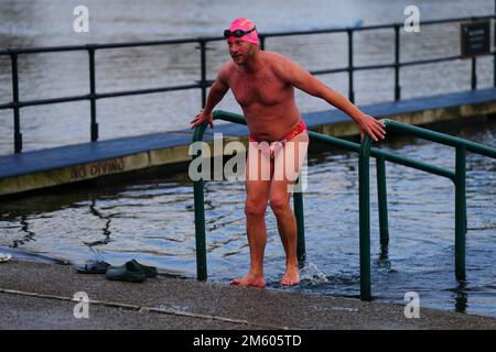 Un homme prend une baignade tôt le matin le jour de l'an au Serpentine à Londres. Date de la photo: Dimanche 1 janvier 2023. Banque D'Images