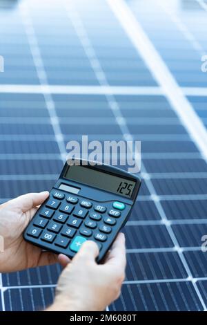Concept d'économie d'énergie avec panneaux solaires et une calculatrice Banque D'Images