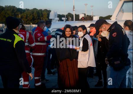 Roccella Jonica, Italie. 31st décembre 2022. Migrants vus au port après leur arrivée. Près de 90 migrants, principalement d'Afghanistan, du Pakistan et d'Iran, ont été sauvés par la Garde côtière italienne et emmenés au port de Roccella Jonica « Porto Delle Grazie ». Un bébé, né il y a trois jours pendant le passage à niveau, un nouveau-né de 11 jours et un bébé de cinq mois étaient également à bord. Des membres de la Croix-Rouge, des médecins sans frontières et du personnel sanitaire ont aidé les bébés, leurs familles et d'autres migrants. Crédit : SOPA Images Limited/Alamy Live News Banque D'Images