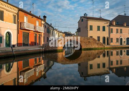 Maisons et pont reflétés dans le canal, via Agatopisto Cromaciano, Comacchio, Emilia Romagna, Italie Banque D'Images