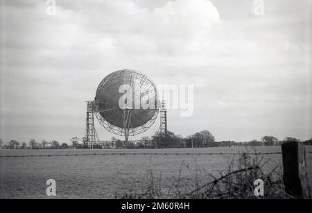 Fin 1950s, vue historique du télescope Mark i ou Lovell, Cheshire, Angleterre, Royaume-Uni, le plus grand radiotélescope parabolique du monde lors de sa construction en 1957. Le radiotélescope porte le nom de Bernard Lovell, un astronome radiophonique de l'Université de Manchester qui a établi un observatoire - l'Observatoire de la banque Jodrell - dans le nord-ouest de l'Angleterre en 1945 pour étudier les rayons cosmiques, en continu le travail qu'il avait entrepris sur le radar pendant la Seconde Guerre mondiale. En 1988, le Lovell Telescope a été construit dans un bâtiment classé de catégorie I, ce qui signifie qu'il s'agit d'un bâtiment d'un « intérêt exceptionnel ». Banque D'Images