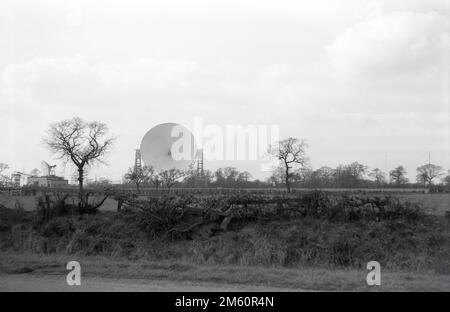 Fin 1950s, vue historique du télescope Mark i ou Lovell, Cheshire, Angleterre, Royaume-Uni, le plus grand radiotélescope parabolique du monde lors de sa construction en 1957. Le radiotélescope porte le nom de Bernard Lovell, un astronome radiophonique de l'Université de Manchester qui a établi un observatoire - l'Observatoire de la banque Jodrell - dans le nord-ouest de l'Angleterre en 1945 pour étudier les rayons cosmiques, en continu le travail qu'il avait entrepris sur le radar pendant la Seconde Guerre mondiale. En 1988, le Lovell Telescope a été construit dans un bâtiment classé de catégorie I, ce qui signifie qu'il s'agit d'un bâtiment d'un « intérêt exceptionnel ». Banque D'Images