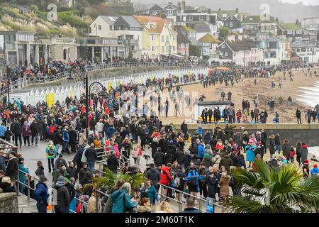 Lyme Regis, Dorset, Royaume-Uni. 1st janvier 2023. Météo Royaume-Uni. Les familles et les visiteurs de Pack la plage et le front de mer à Lyme Regis à Dorset avant la course annuelle de la charité de Lyme Lunge sur un humide et couvert jour du nouvel an. Crédit photo : Graham Hunt/Alamy Live News Banque D'Images