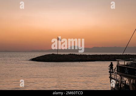 Drapeau turc silhouette sur des rochers au milieu d'un paysage marin magnifique au coucher du soleil Banque D'Images