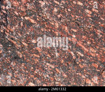 Arrière-plan de texture de granit rouge avec de petits cristaux et inclusions, gros plan Banque D'Images