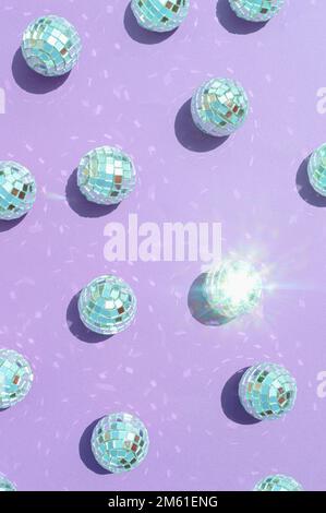 Motif composé de boules disco avec éclat naturel du soleil sur fond violet. Concept de fête esthétique rétro lumineux et ensoleillé. Noël et New Ye Banque D'Images