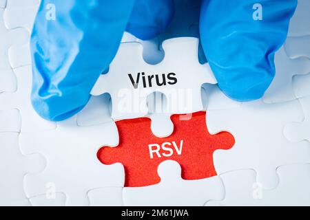 Virus RSV 'virus syncytial 'concept de santé, maladie dangereuse pour les enfants, saison de la grippe, Inscription sur les pièces de puzzle tenues dans la main du médecin Banque D'Images