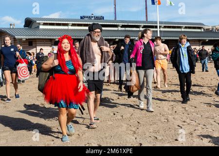 Brooklyn, NY, États-Unis. 1st janvier 2023. Des milliers de baigneurs et de spectateurs se sont présentés lors d'un nouvel an ensoleillé et chaud pour le Polar Bear Plunge annuel à Coney Island, parrainé par l'Alliance pour Coney Island. Une femme vêtue d'une robe de natation brillante et portant une perruque rouge et une tête de tutu rouge pour l'eau. Credit: Ed Lefkowicz/Alay Live News Banque D'Images