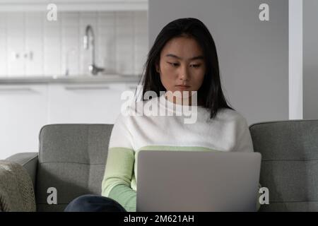 Fille asiatique utilisant le chat d'ordinateur portable sur le site de rencontres en ligne ou à la recherche de nouveaux amis sur les médias sociaux Banque D'Images