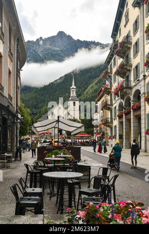 Vue sur la rue du centre-ville avec l'église Saint Michel et le pic de Brevent (2525 m) dans un ciel nuageux jour d'été, Chamonix, France Banque D'Images