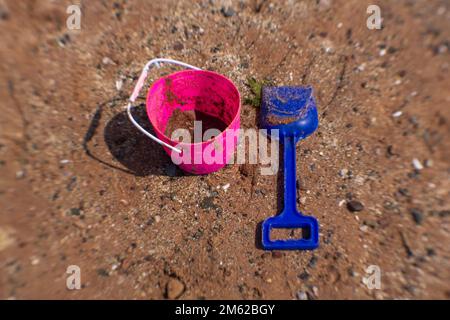 Seau et ombre sur une plage de sable Banque D'Images