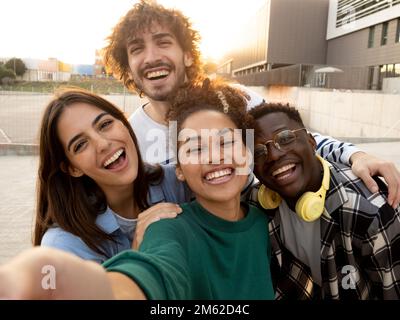 Groupe de jeunes amis adolescents divers ayant un bon moment dans la rue Banque D'Images