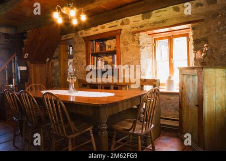 Ancienne table à manger et chaises en bois dans la salle à manger à l'intérieur de la vieille maison de style cottage datant de 1850. Banque D'Images