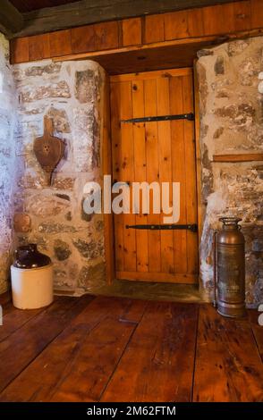 Porte de salle de bains en bois de style médiéval et grands planchers à l'intérieur de la vieille maison en pierre de style chalet datant de 1850. Banque D'Images