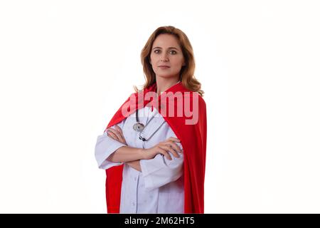 super-héros et leader concept- portrait de gaie femme médecin avec cape de héros rouge debout avec les bras pliés, isolé sur fond blanc. Banque D'Images
