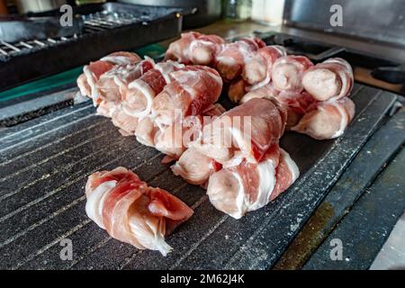 Saucisse surgelée enveloppée de bacon ou de cochons dans des couvertures décongelées prêtes à cuire Banque D'Images