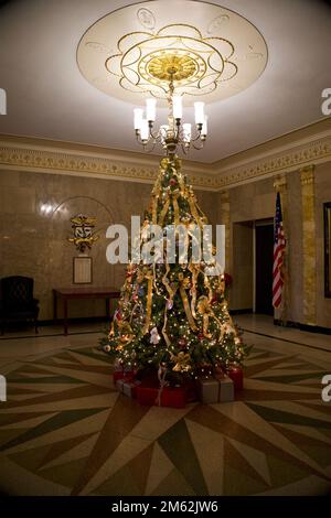 Arbre de Noël à l'intérieur de Clinton, hôtel de ville du Connecticut. L'arbre est éclairé avec des cadeaux en dessous et un beau lustre au-dessus. Banque D'Images