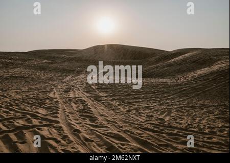 Marques de pneus de voiture sur les dunes de sable du désert de Thar, Rajasthan, Inde. Les touristes arrivent sur des voitures pour regarder le soleil se lever dans le désert , une activité touristique très populaire . Banque D'Images