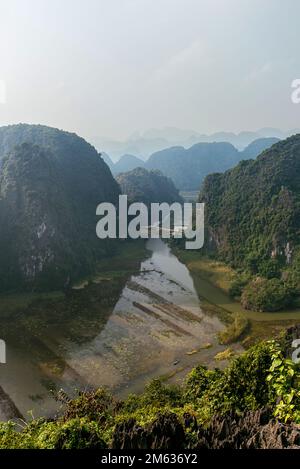 De dessus vue panoramique de rivière étroite qui coule à travers les collines couvertes de plantes vertes le jour ensoleillé au Vietnam Banque D'Images