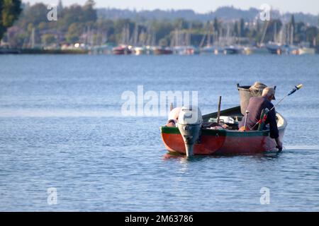 Pêcheur sur un petit bateau jetant ses filets pour la pêche Banque D'Images