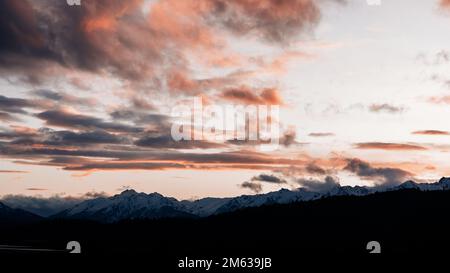 Vue à couper le souffle sur les montagnes immenses et rugueuses couvertes de neige sous un ciel nuageux et sombre au coucher du soleil situé à Cholila Banque D'Images