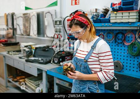 Mécanicien vérifiant le système de freinage à étrier devant l'établi Banque D'Images