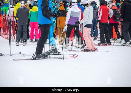 Slovaquie, Jasna - 4 février 2022: Personnes en ligne pour télésiège de ski Banque D'Images